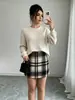 Conjunto de dos piezas europeo y americano para mujer 2026: Suéter de punto grueso a rayas verticales color blanco roto + Pantalones de cuadros marrones y negros de cintura alta vintage