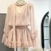 Moda de primavera: Un impresionante vestido rosa de estilo coreano con cuello con volantes, ceñido a la cintura y falda corta tipo tea break, ideal para personas menudas.