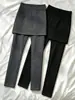 Pantalones negros de tiro alto ajustados con una falda incorporada que cubre el trasero, diseñados para ocultar las caderas y crear un efecto adelgazante, adecuados para que las mujeres los usen como prenda exterior en otoño