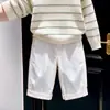 Nueva colección de otoño/invierno 2026 para niños estilo coreano: Suéter de punto color hueso con rayas verdes, combinado con pantalones blancos de pierna ancha - un conjunto de dos piezas