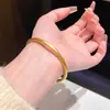 Estilo boutique de oro, pulsera tradicional chapada en oro, una pieza de joyería ligera y versátil para el uso diario, con un diseño de banda sólida y lisa, disponible para venta al por mayor
