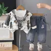 Conjunto casual de três peças para bebês e crianças pequenas para primavera/outono, apresentando uma jaqueta com capuz estampada com ursinhos de desenho animados, combinada com roupa íntima estampada e jeans.