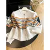 2026 Invierno Estilo Retro Perezoso Bloque de Color Raya Solapa Única Cuello Redondo Suave Holgado Casual Top de Punto para Mujer