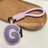 Venta al por mayor transfronteriza de llaveros japoneses y coreanos con letras en inglés, dijes para bolso de cuero dopamina, pequeños accesorios y regalos