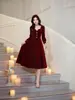 Vestido vintage de terciopelo para mujer, de cuello cuadrado, largo medio, manga larga, con cintura alta y falda amplia, creando un elegante y atmosférico vestido rojo.