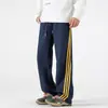 Nuevos pantalones deportivos casuales holgados a rayas con bloques de color de otoño para hombres y mujeres, pantalones deportivos versátiles de pierna ancha estilo americano