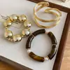 Pulsera Circular con Forma de Concha de Resina y Metal Chapado en Oro Ámbar, con un Toque de Lujo Ligero y de Alta Gama, Accesorio de Mano Simple y de Moda