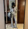 Conjunto casual e descontraído estilo coreano para o início do outono: moletom de manga longa assimétrico, ombro a ombro, sem capuz e calça de perna larga, conjunto de duas peças para mulheres