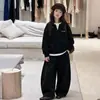 Conjunto de roupas esportivas de outono estiloso e moderno para meninas, com um moletom de duas peças falso e calças de moletom casuais em estilo coreano