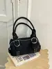 Bolso de axila versátil estilo coreano transfronterizo, moderno y de alta calidad, con un diseño texturizado tipo dumpling, acabado de gamuza y detalles de remaches, perfecto para ir al trabajo