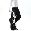 Jeans de calle estilo americano ligeros con estampado de graffiti de alas y costuras de contraste, pantalones de algodón unisex de pierna ancha curvada multibolsillos hasta el suelo