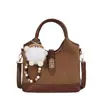 Nuevo modelo de principios de otoño 2026, bolso de mano con diseño personalizado, bolso tipo cubo moderno y sencillo, bolso cruzado de moda para el trabajo y los desplazamientos