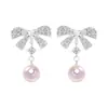 Únicos y elegantes, estos dulces pendientes de lazo con incrustaciones de diamantes y perlas exudan un aura elegante y sofisticada, ofreciendo un toque de lujo y versatilidad para cualquier atuendo.