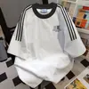 Camiseta de Manga Curta com Estampa de Letras e Listras Três Listras de Design de Nicho para Homens e Mulheres, Tops Casuais Soltos de Casal para o Verão 2025
