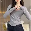 Camisa feminina base vazada em cruz com pregas de botão lateral, acinturada, barra irregular, top justo de manga longa