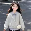 Atuendo elegante y moderno para niñas 2026: top de moda tipo dos piezas con un cuello elegante, combinado con pantalones sencillos y casuales, un conjunto de dos piezas versátil