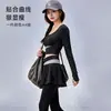 Conjunto de yoga de dos piezas de alta gama en bloques de color para mujer, cuello redondo, top corto de manga larga, cintura cruzada, pantalón falda de dos piezas falsas, deportivo