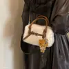 Bolso de mano para mujer estilo commuter, minimalista y sutilmente lujoso para el otoño de 2026, con un diseño afelpado, versátil para llevar al hombro o cruzado.