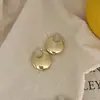 Nuevos pendientes redondos lisos pendientes otoño e invierno lujo ligero gama alta exagerados moda temperamento nicho pendientes de aguja de plata