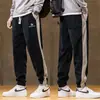 Calça de moletom esportiva masculina da moda para primavera, versátil, de corte solto, novas calças jogger de corte justo com cores contrastantes, calças casuais
