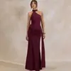 Vestido de noche asimétrico de un hombro con cuello alto, pliegues en capas en la cintura, tirantes largos y fluidos, y bajo de sirena con abertura.