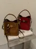 Bolsa Saco Retro Camurça Melanóide Feminina 2026 Outono/Inverno Nova Bolsa de Mão Trançada Pingente de Miçangas Bolsa de Ombro Único Transversal