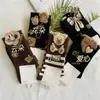 Meias populares de urso na cor marrom café para outono e inverno para mulheres, meias altas e meias de cano médio com urso tridimensional de fio de pena anti-odor