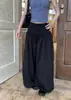 Pantalones casuales hechos a medida de tiro alto, con botones al frente, corte holgado y pierna ancha, creando una silueta relajada y estilizada; pantalones tipo linterna grises, chic sin esfuerzo