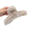 Coleção Outono/Inverno 2026: presilha de cabelo de pelúcia com design de tubarão para a parte de trás da cabeça, criando um look estiloso e retrô em uma sofisticada cor marrom, adequada para mulheres