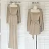 Un elegante conjunto de principios de otoño: un conjunto completo que incluye un vestido camisola, un cárdigan y un par de pantalones