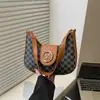 Bolsa feminina da moda, tendência primavera 2025, com cinto decorativo, estilo retrô, para usar de ombro ou de baixo. Estampa de letras. Modelo casual.