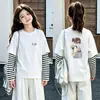 Camiseta de algodón a rayas de manga larga, estilo coreano y moderna, para niñas, un nuevo diseño de primavera/otoño, corte holgado, versátil y con cuello redondo, adecuada para niños de talla mediana a grande