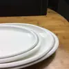 Venta directa de fábrica de platos ovalados para pescado de cerámica blanca pura con borde grueso, adecuados para uso en hoteles, restaurantes y cenas en casa.
