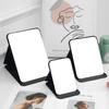 Espejo de maquillaje de PU, espejo de escritorio plegable portátil, espejo de tocador cuadrado para dormitorio de estudiantes, espejo pequeño de escritorio al por mayor