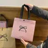Tienda de ropa bolso de mano no tejido para mujer en stock embalaje para regalo bolsa de regalo bolsa de compras cinturón de embalaje para ropa venta al por mayor