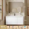 Tocador de baño engrosado y ahorrador de espacio con diseño en color crema, que cuenta con un lavabo redondeado, lavabo cerámico integrado y un lavabo de una sola pieza.