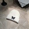 Gorro de lana de punto con diseño de mariposa para mujer, estilo coreano, ideal para celebridades de internet, cálido y de moda en color puro.