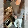 Camisa base elegante de color liso con ribete de volantes, corte ajustado para mujer, nueva colección de punto casual versátil de manga larga para la primavera de 2025