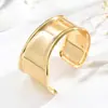 Estilo ins minimalista dorado pulsera de puño ancho abierto diseño de superficie de espejo aerodinámica irregular sentido de diseño joyería de lujo ligero para mujer