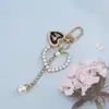 Llavero Colgante Forma de Corazón con Lazo y Perlas Estilo Chanel para Funda de Teléfono Bolso Encanto Regalo Pequeño Accesorios DIY