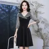 Vestido negro corto de línea A con cuello en V, paneles de malla con lentejuelas, mangas cortas y cintura ceñida, adecuado para eventos formales de noche.