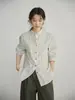 Yinhe STUDIO: A mesma camisa verde listrada com gola alta, feita de linho francês e com acabamento encolhido em sal, como a usada por Guo Yuxin