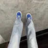 Jeans azul claro, ligeramente acampanados para hombre, perfectos para atuendos de otoño, creando un efecto de piernas largas, corte limpio, pantalones de corte recto con pierna curva