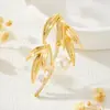 Suministro directo de fábrica de nuevo broche de perla con hoja de bambú estilo chino, chapado en cobre con oro real, incrustado con circonita, estilo nacional, lujo ligero, elegante pasador para traje