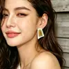 Pendientes de botón geométricos únicos con bloques de color y acabado dorado cepillado, pendientes de diseño de nicho vintage con un ambiente retro y elegante.