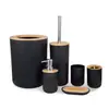 Conjunto de banheiro em bambu e madeira com lavatório, bancada, artigos de higiene pessoal, escova sanitária e lixeira.
