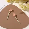Design original: Acessórios de cabelo e enfeites de roupa florais em miniatura apresentando uma vibrante cena de prado verde com pequenas contas e ramos de flores retorcidos