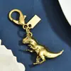 Múltiples Estilos de Llaveros de Aleación Dorada con Colgantes de Dinosaurio, Trébol de Cuatro Hojas y Corazón, Accesorios de Cierre de Langosta y Exquisitos Adornos