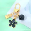 Llavero de Metal Pequeña Flor Estilo Ins con Goteo de Aceite Doble Cara con Etiqueta Pequeña y Cascabel Colgante para Bolsa de Auriculares de Niñas