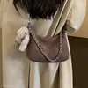 Bolso para mujer 2026 Nuevo estilo coreano, bolso de mano, bolso de axila, bolso de hombro cruzado vintage de invierno con colgante de conejo de peluche, gamuza de moda